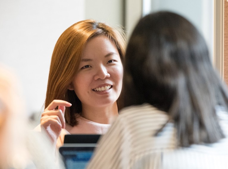 Close-up of a woman's face as she explains something to a coworker.