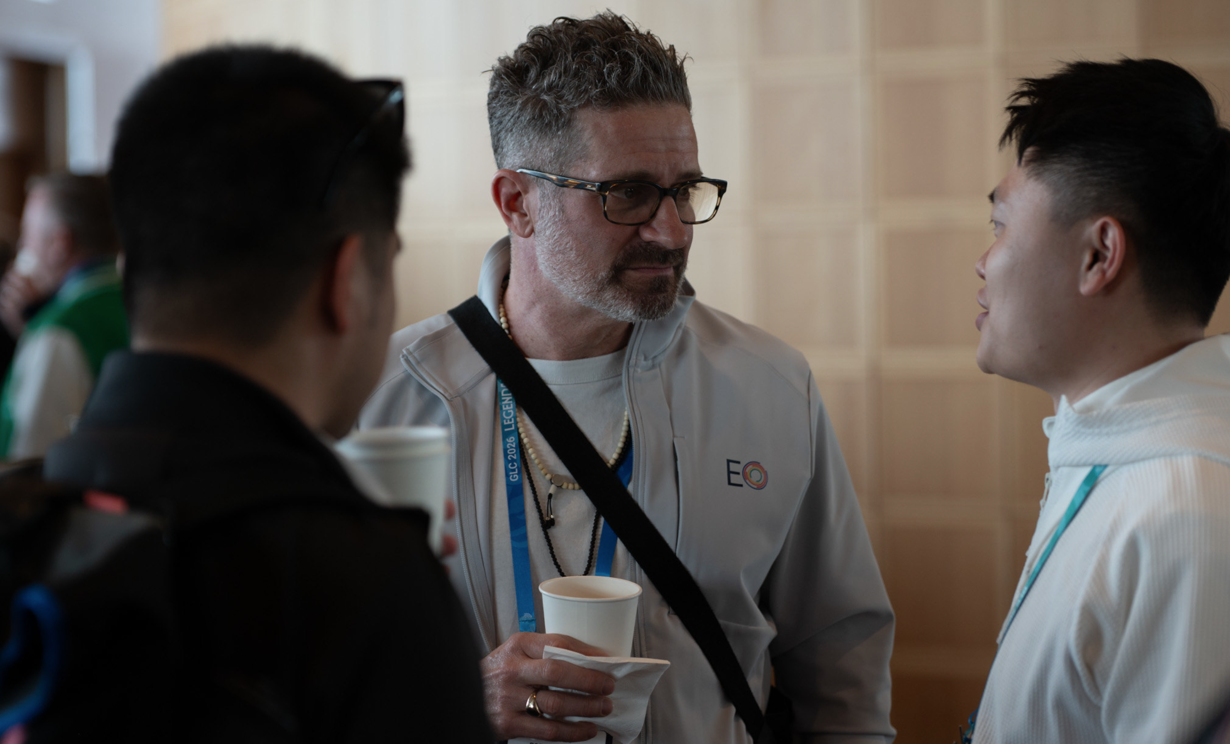 Three entrepreneurs in casual dress have a serious discussion over coffee.
