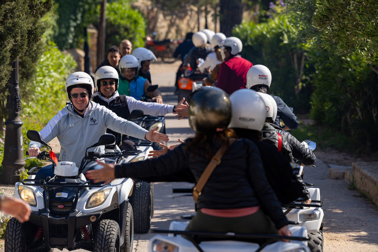 A group of entrepreneurs driving and interacting on four-wheel drive scooters.