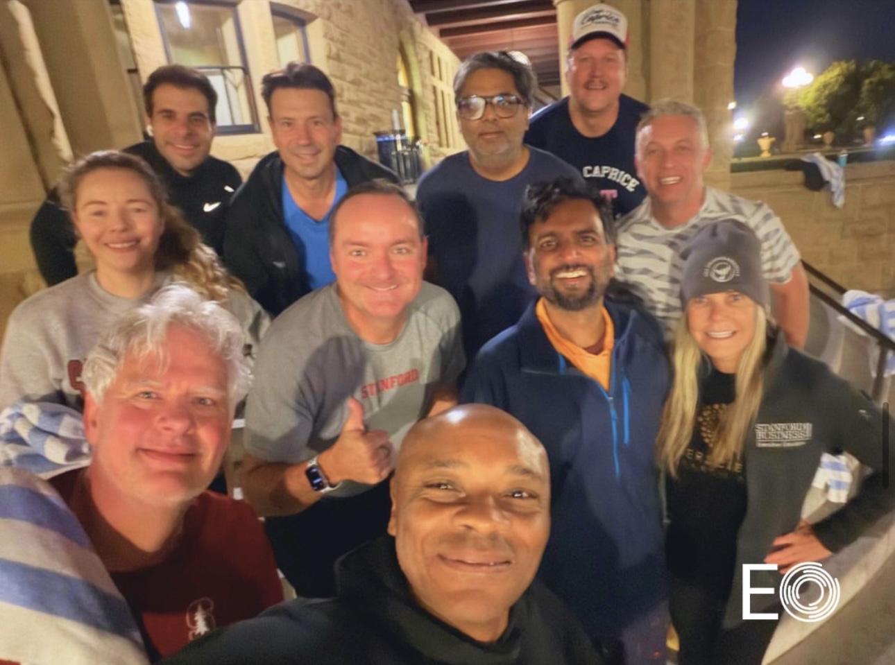 Eleven attendees of EO's inaugural AI Lab at Stanford pose together in a casual setting.