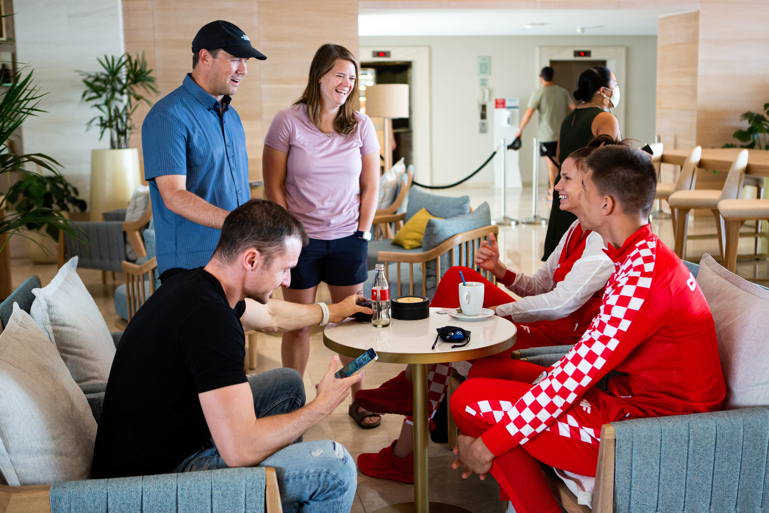 Five young founders dressed casually meet for coffee.