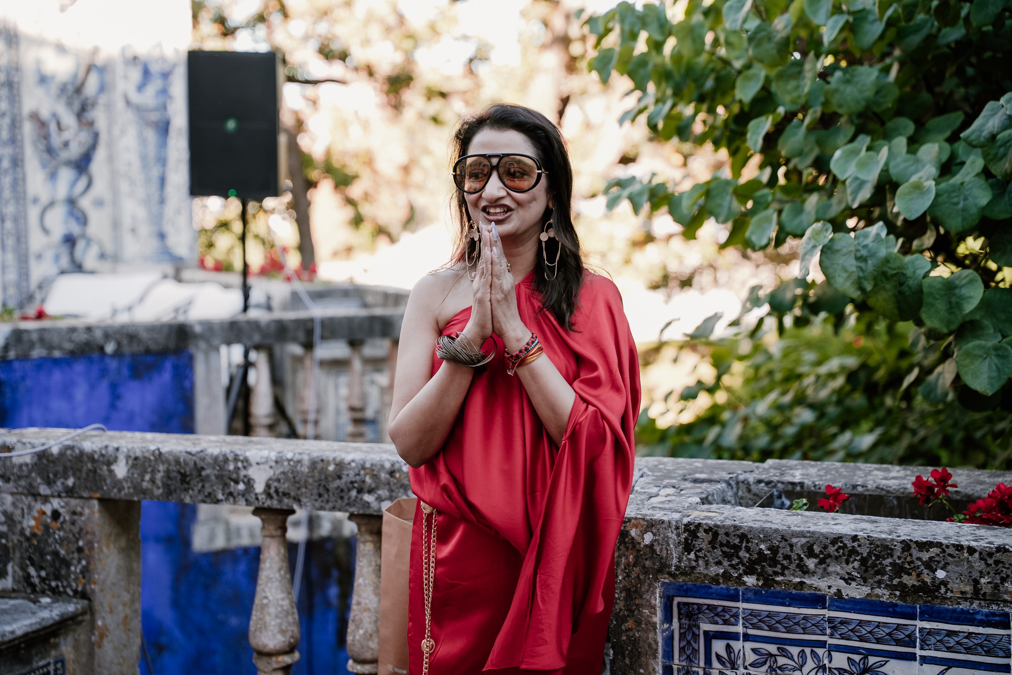 A fashionable woman in a red dress shares her thoughts in an outside setting.