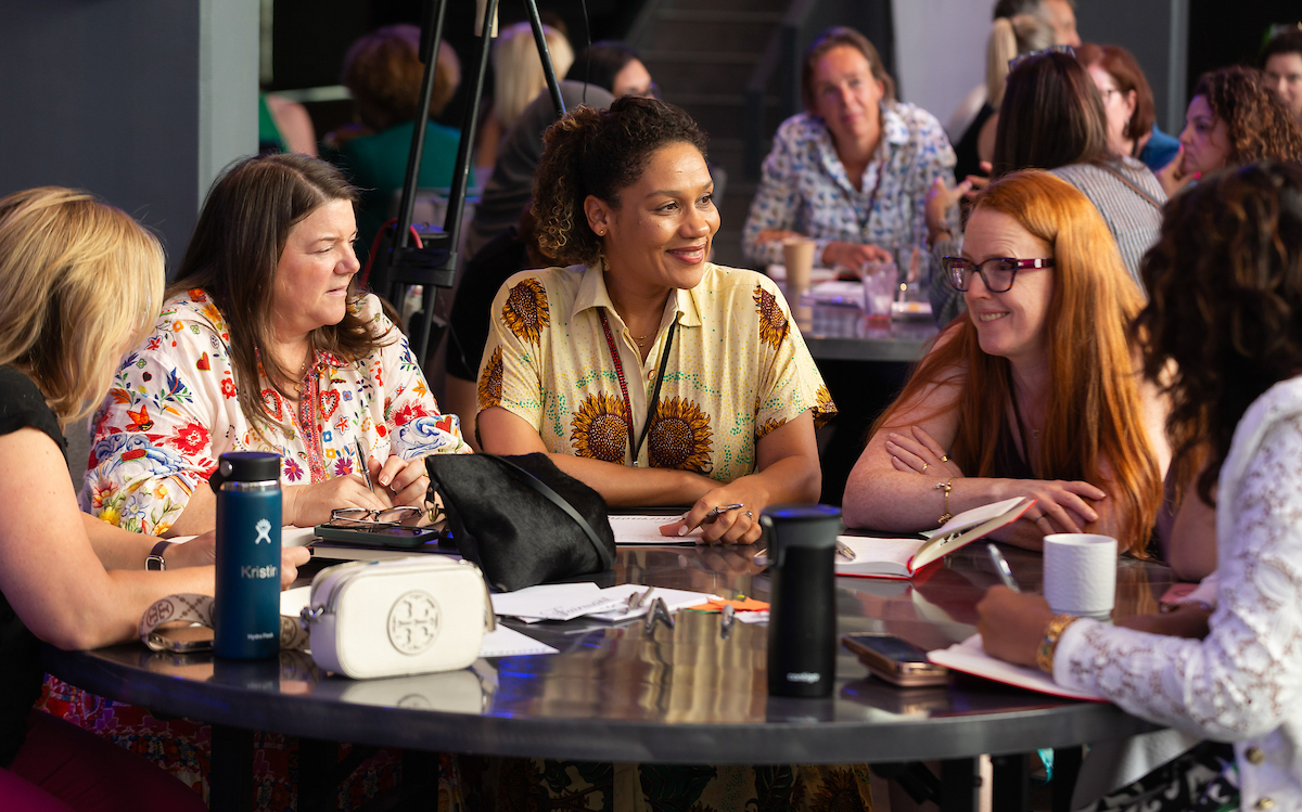 A table of women enjoy a networking event.