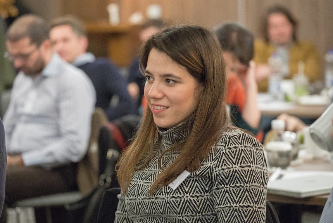 A woman listens to a speaker at a learning event.