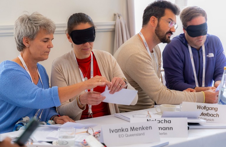Four entrepreneurs in groups of two lead a blindfolded partner through a simple exercise in communication and trust.