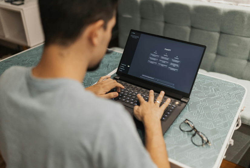 A man types on a laptop computer screen using ChatGPT.