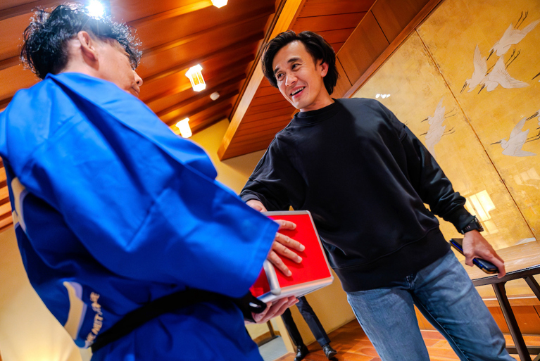 Two men shake hands.