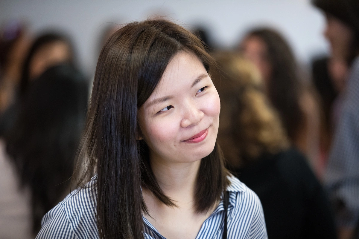 An Asian woman with an intelligent, knowing smile on her face.