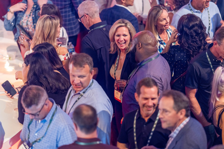 In a sea of professionals, a woman with a genuine smile connects with another participant.