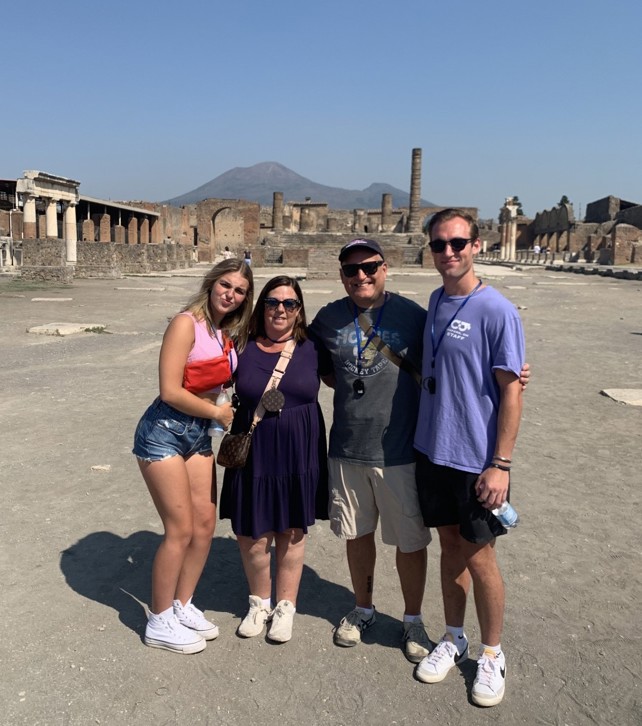 A family of four stand among the ruins of Pompeii, Italy.